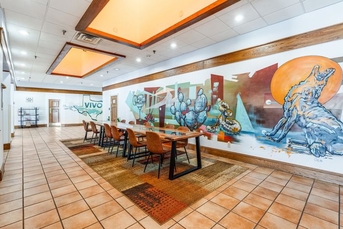 Bright and artistic communal area with vibrant mural, featuring modern seating and a welcoming atmosphere at Vivo Living.