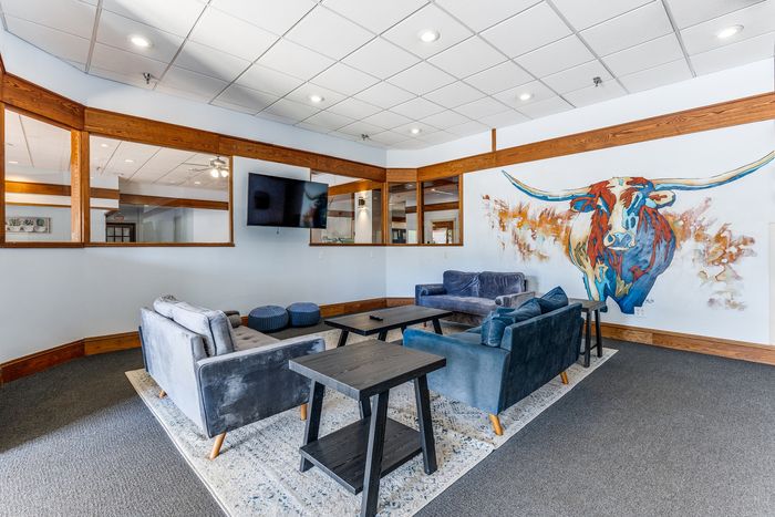 Chic modern lounge with trendy blue sofas and captivating artwork of a colorful bull on the wall.