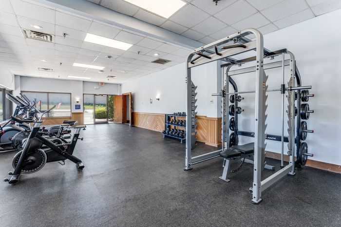 Modern fitness center featuring state-of-the-art exercise equipment, natural light, and a clean, spacious layout for optimal workouts.