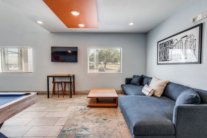 Living area at Gruene Pointe in New Braunfels, TX with a sectional sofa and artwork