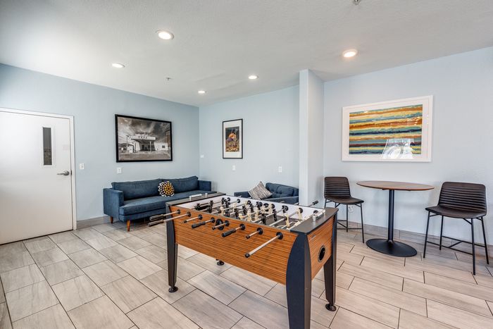 Recreation room at Gruene Pointe in New Braunfels, TX with a foosball table and blue sofas