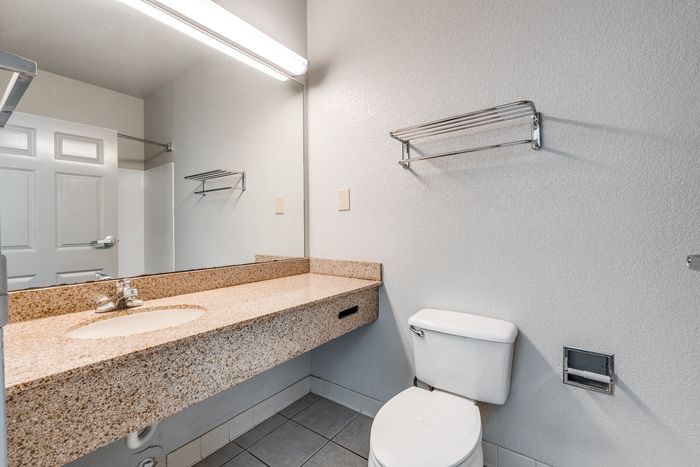 Bathroom at Gruene Pointe in New Braunfels, TX with a granite countertop and large mirror