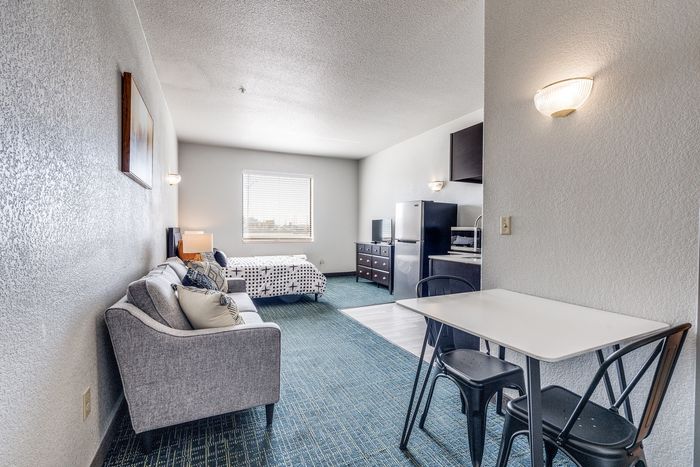 Studio interior at Gruene Pointe in New Braunfels, TX with a kitchenette and bed by a window