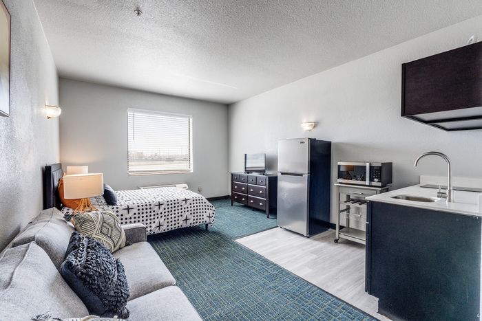 Studio apartment at Gruene Pointe in New Braunfels, TX with a bed, seating area, and kitchenette