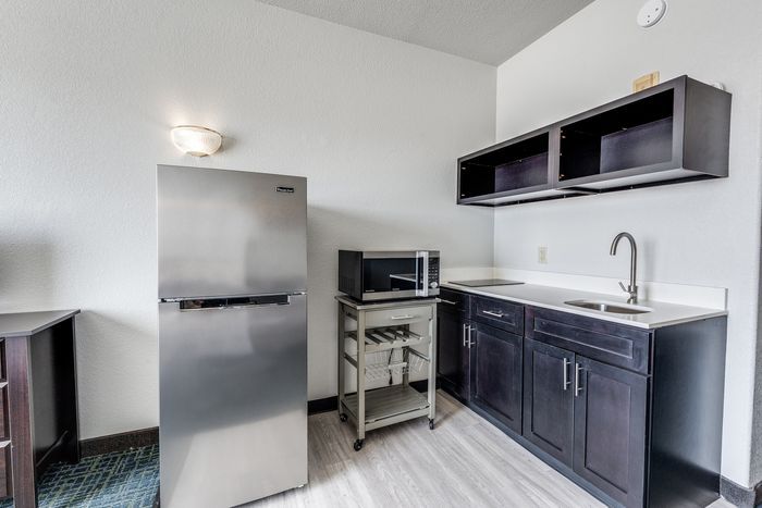 Studio kitchenette at Gruene Pointe in New Braunfels, TX with a stainless fridge and dark cabinets