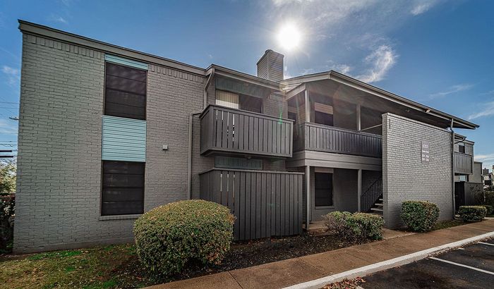 Gray brick apartment building with private balconies at Dakota Apartments in Fort Worth