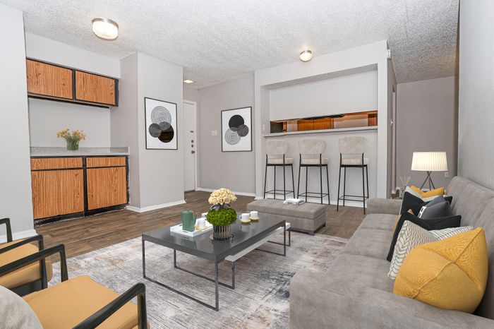 Living room with seating and bar stools in a Dakota Apartments unit