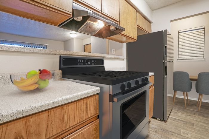 Kitchen with an electric stove and a dining nook in a Dakota Apartments unit