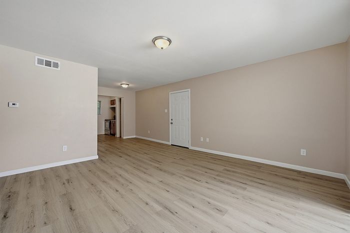 Living area with wood-style flooring next to the kitchen at The Crawford at Denison