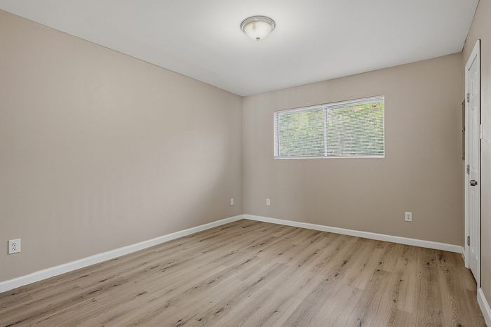 Bedroom with wood-style flooring and a large window at The Crawford at Denison