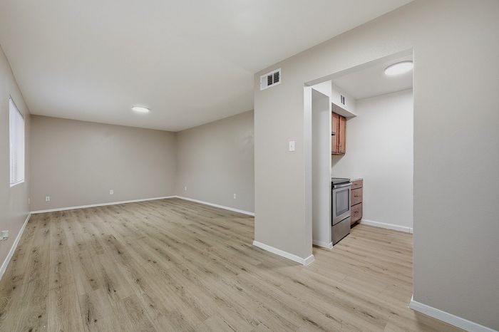 Living area with wood-style flooring next to the kitchen at The Crawford at Denison
