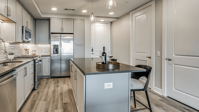 Apartment kitchen with gray cabinetry and counter space at Oslo on 6th in Aurora, CO
