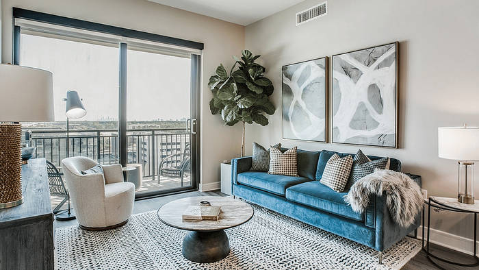 Living area with a sofa, rug and sliding glass door in an apartment at Oslo on 6th, Aurora CO