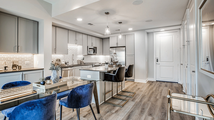 Kitchen and dining area with cabinetry and seating at Oslo on 6th in Aurora, Colorado