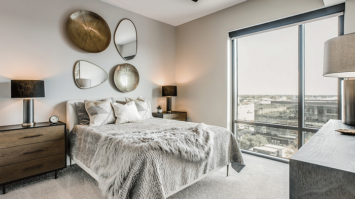 Bed and wall art beside a window in a studio apartment at Oslo on 6th, Aurora CO