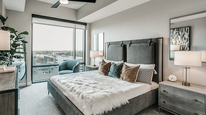 Bed and wall art beside a window in a studio apartment at Oslo on 6th, Aurora CO