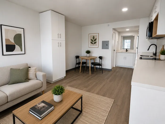 Modern open-concept living room and kitchen with stylish decor, cozy seating, and natural light highlighting elegant wood flooring.