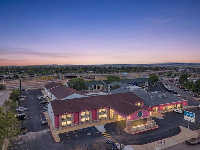 Aerial view of Juniper Flats studio apartments in Albuquerque, NM at dusk with the main building and parking