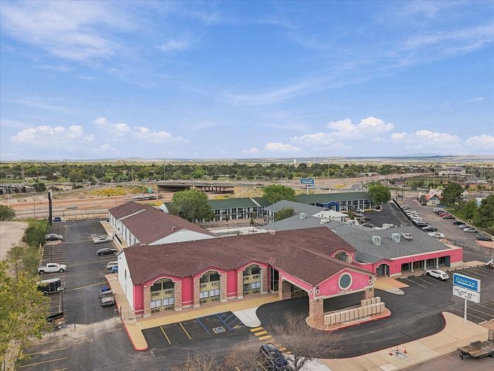 Daytime aerial view of Juniper Flats apartments in Northeast Albuquerque with main building, wings and parking