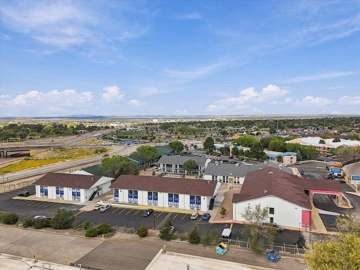 Aerial view of two-story white residential buildings with blue trim at Juniper Flats in Albuquerque, NM