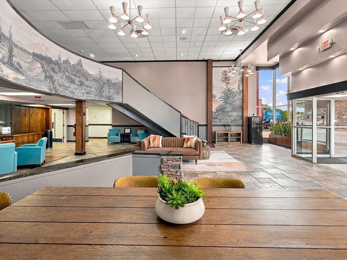 Lobby communal table with lounge seating and staircase in the background at Juniper Flats