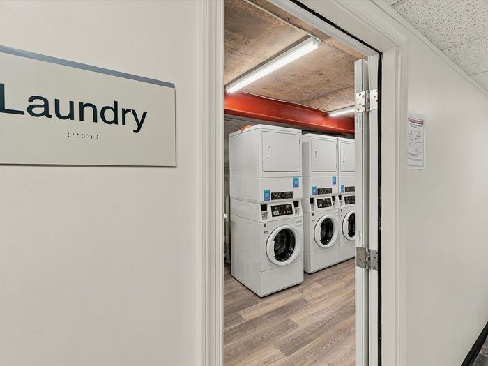 Entrance to the on-site laundry room with stacked washers and dryers at Juniper Flats in Albuquerque