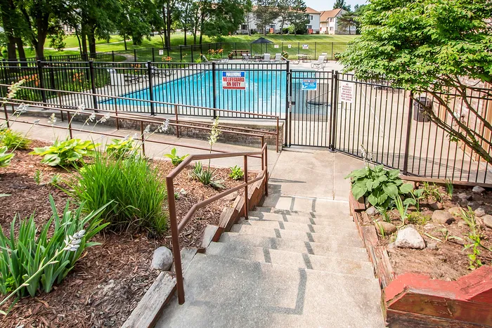Inviting outdoor pool area with lush greenery and convenient access, perfect for relaxation and enjoyment.