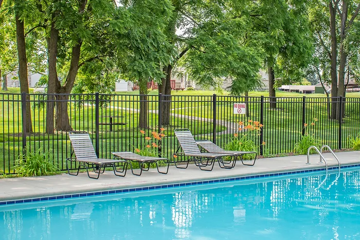 Charming outdoor swimming pool area with lush greenery, lounge chairs, and a peaceful ambiance.