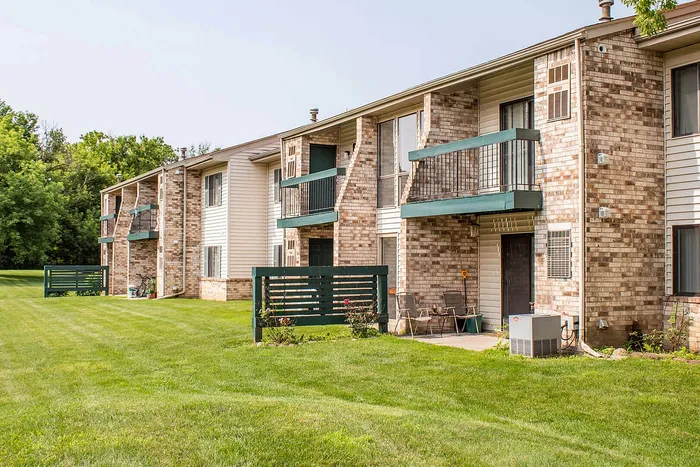Charming apartment complex with spacious balconies overlooking lush green lawns, perfect for relaxation and vibrant community living.