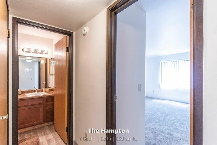 Bright one-bedroom apartment featuring a modern bathroom with elegant lighting, located in The Hampton, offering 630 sq. ft. of comfortable living space.