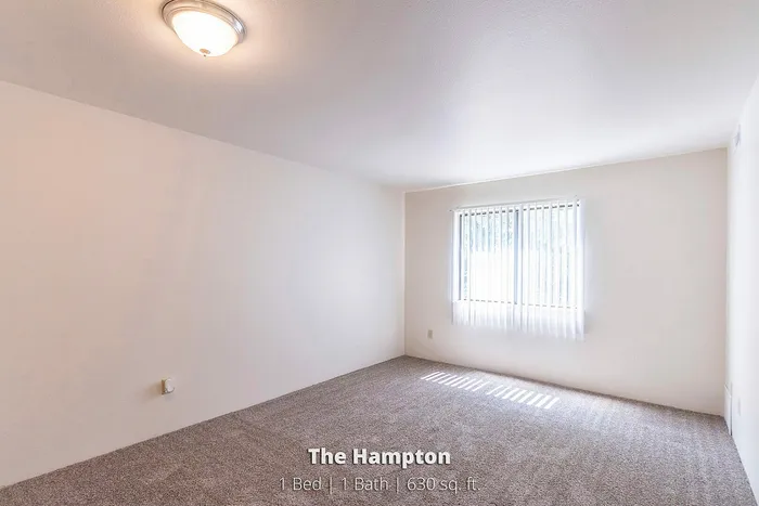 Bright and spacious bedroom in The Hampton, featuring plush carpeting and ample natural light, 1 bed 1 bath, 630 sq ft.