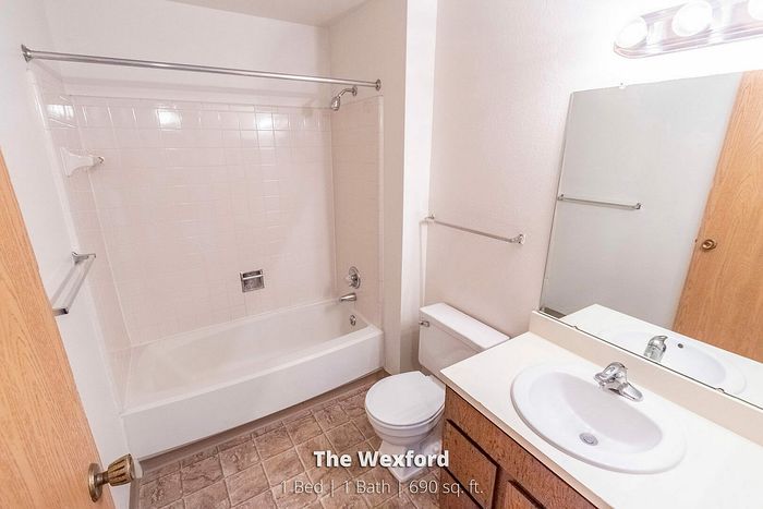 Bright and welcoming bathroom in The Wexford, featuring modern fixtures, a spacious bathtub, and stylish tile flooring. Part of a 1 Bed, 1 Bath unit with 690 sq. ft.