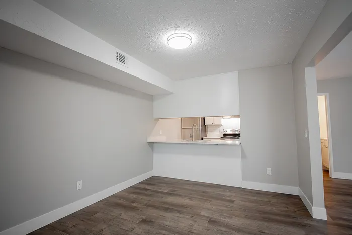 Chic apartment interior showcasing an open-plan layout with modern finishes, hardwood floors, and a sleek kitchen with a breakfast bar.