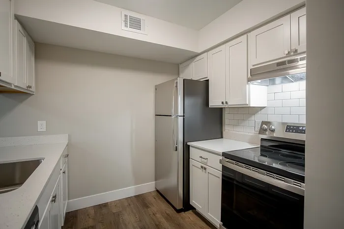 Modern kitchen with sleek stainless steel appliances, elegant white cabinetry, and stylish subway tile backsplash.