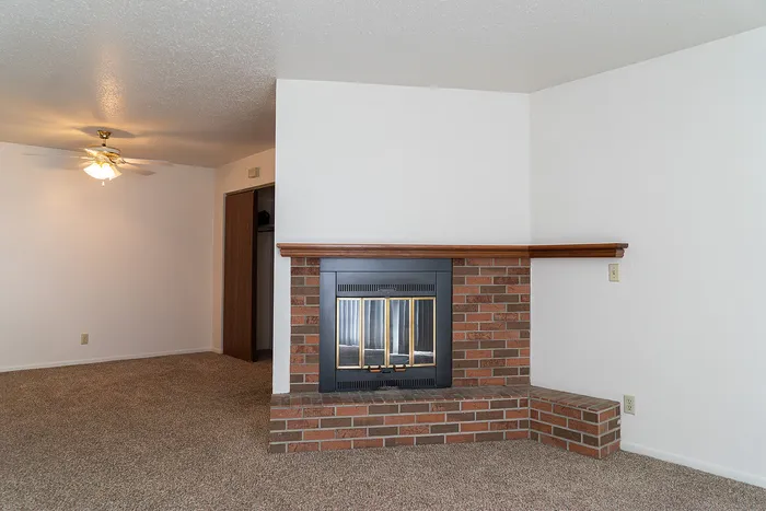 Charming living area with a cozy brick fireplace corner and a bright, welcoming ambiance.