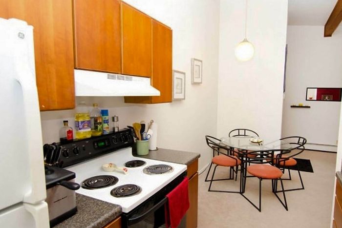 Charming kitchen with modern appliances and cozy dining area featuring a sleek glass table and stylish chairs.