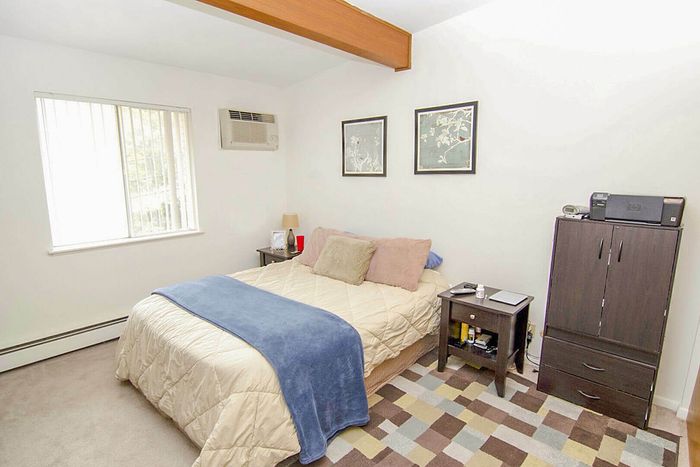 Inviting bedroom with cozy bedding, modern decor, and ample natural light from the window, creating a serene retreat.