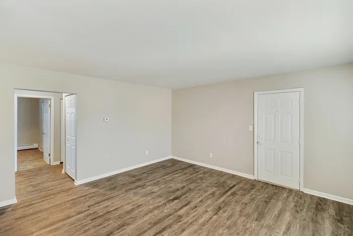 Bright open living space with stylish wood flooring and a modern design, inviting natural light through a clean and minimalistic layout.