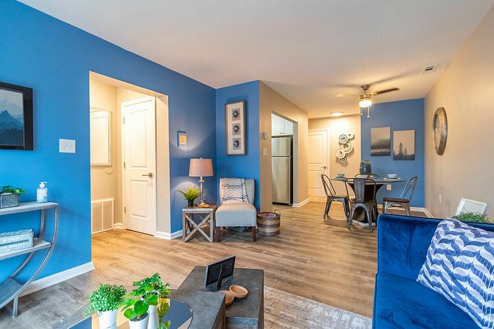 Charming open-concept living area with warm blue accents, cozy seating, and a stylish dining nook, perfect for modern living.