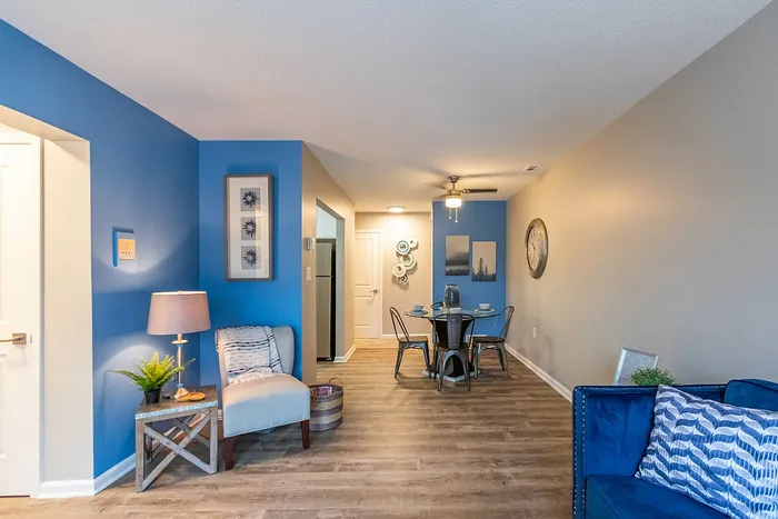 Inviting apartment interior with vibrant blue accents, cozy seating, and stylish dining area for casual gatherings.