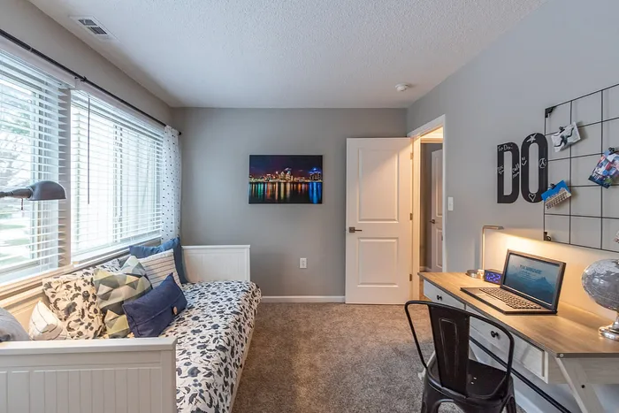Charming home office with cozy daybed, large windows, and a stylish desk setup, ideal for productivity and relaxation.