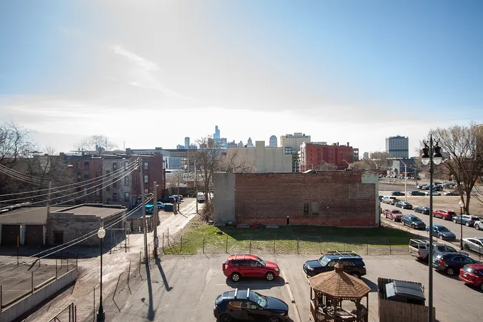 Vibrant urban scene with historic brick buildings, a clear blue sky, and downtown skyline, offering a glimpse of city life and architectural charm.