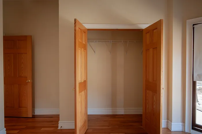 Bright and inviting double-door closet with wooden accents and ample storage space.