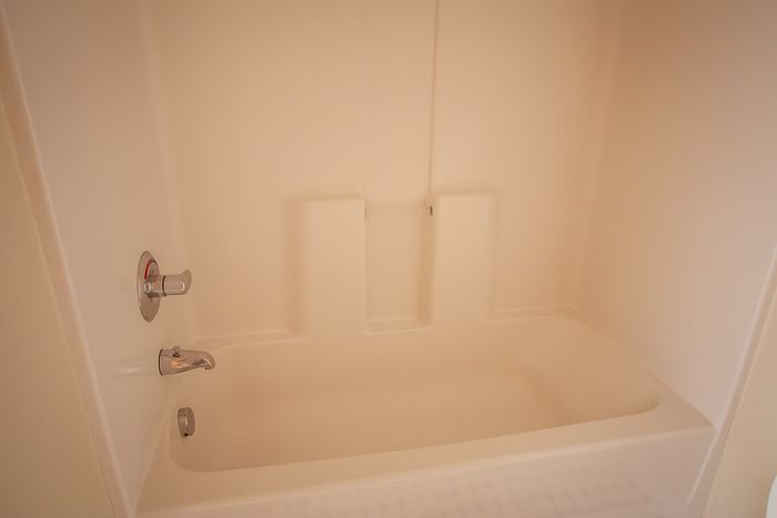 Pristine modern bathroom featuring a sleek, built-in bathtub with elegant fixtures.