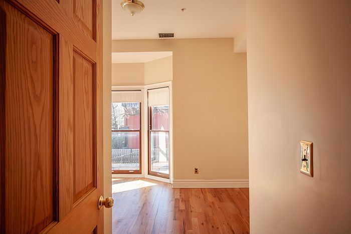 Inviting bedroom with elegant hardwood floors and abundant natural light from large windows.