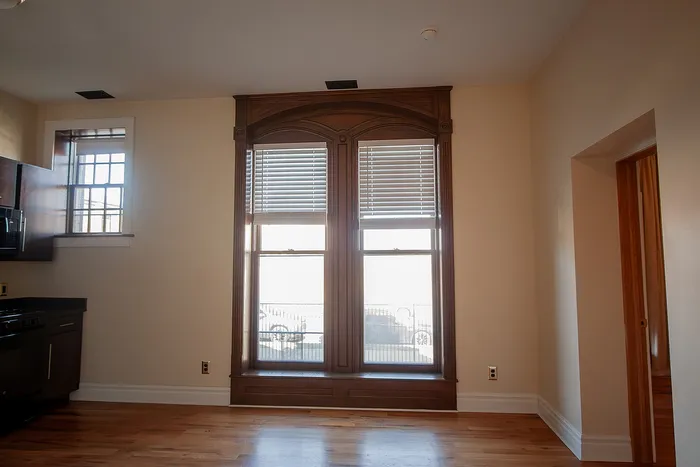 Charming apartment with elegant wooden-framed windows and gleaming hardwood floors, capturing a blend of classic and contemporary design.