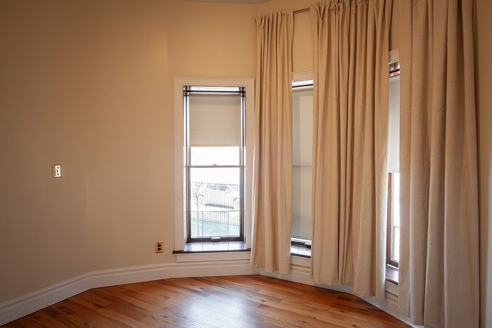 Inviting room with elegant floor-to-ceiling windows and warm hardwood flooring, perfect for serene relaxation.