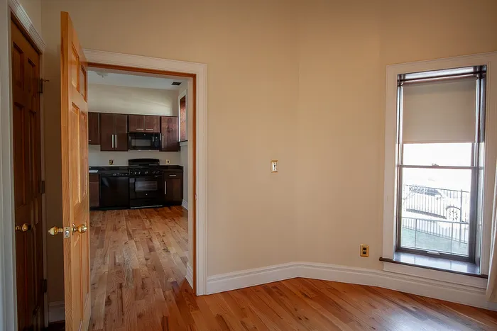 Charming apartment view featuring a sleek kitchen with modern appliances and gleaming hardwood floors.