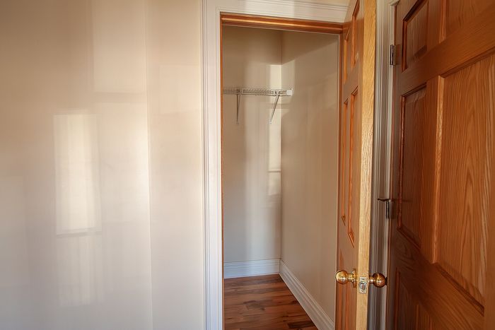 Inviting walk-in closet with wooden doors and ample storage space, perfect for an organized lifestyle.