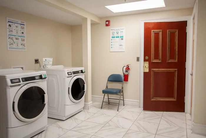 Modern laundry room with sleek washing and drying machines, bright lighting, and clean tile flooring.